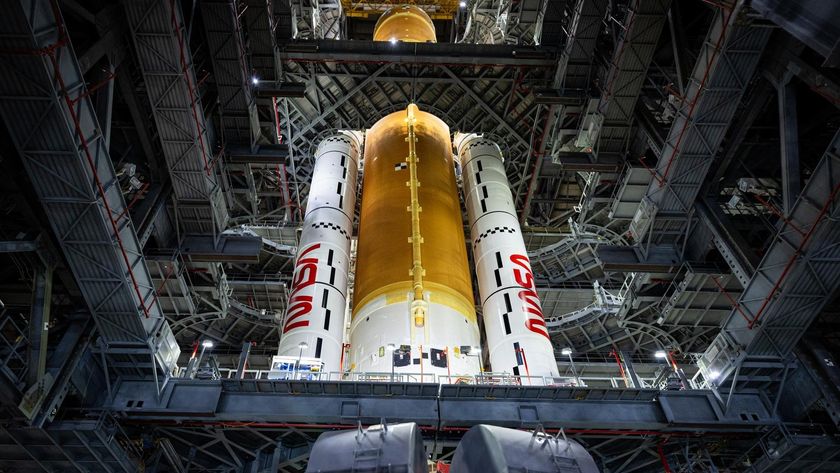a rocket stands upright in a hangar